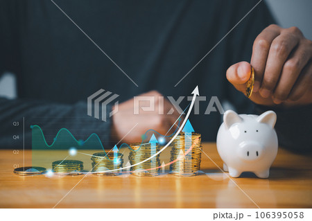 Investment strategy - businessman hand putting coins in a piggy bank with a background of stock market charts and graphs. Saving for future growth and financial security. 106395058