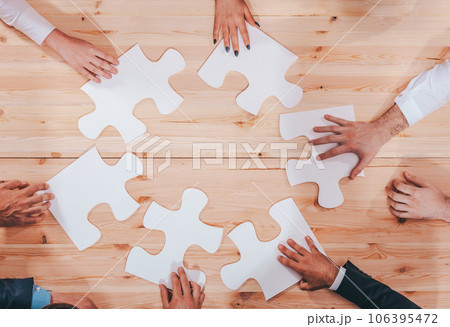 Businessmen working together to build a puzzle as teamwork, partnership and integration concept 106395472