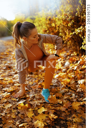 elegant woman in fitness clothes in park stretching 106396753