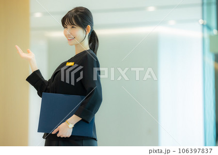 ロビーで案内をする女性 106397837