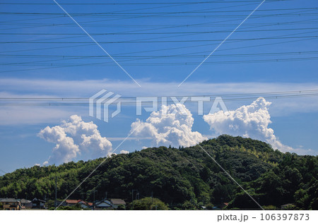 山向こうに立ちのぼる入道雲と送電線 山向こうに立ちのぼる入道雲と送電線 106397873