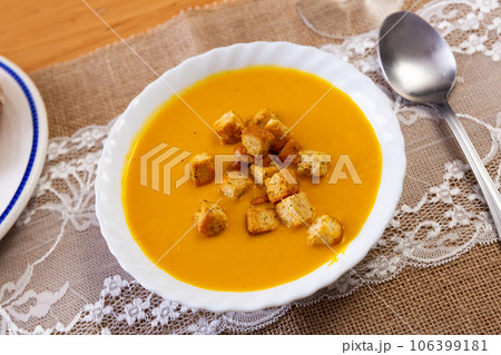 Creamy carrot puree soup served with golden crispy croutons 106399181