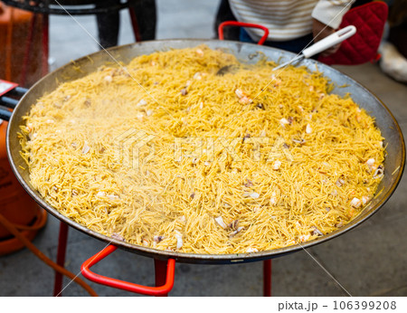 Cooking the Valencian dish Fideua de Marisco Cooking the Valencian dish Fideua de Marisco 106399208