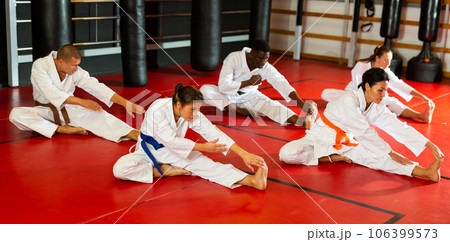 Group of people in kimono stretching before karate training 106399573
