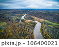 Above aerial shot of green pine forests and yellow foliage groves with beautiful texture of golden treetops. Beautiful fall season scenery in evening. Mountains in autumn colors in golden time 106400021