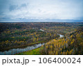 Above aerial shot of green pine forests and yellow foliage groves with beautiful texture of golden treetops. Beautiful fall season scenery in evening. Mountains in autumn colors in golden time 106400024