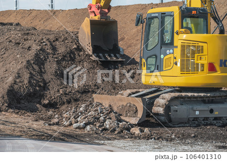 土砂の山を切り崩す重機 土砂の山を切り崩す重機 106401310