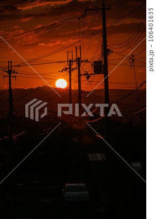 2023夏　奈良市街地の夕景　市街地道路の真正面に沈んでいく夕日(縦)⑥ 106401635