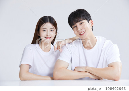 korean asian young couple sitting with hands on shoulders 106402048