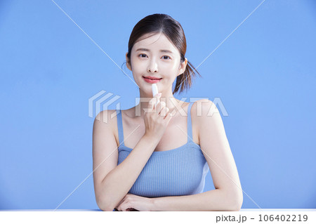 beauty concept photo of korean asain beautiful woman holding a lipbalm 106402219