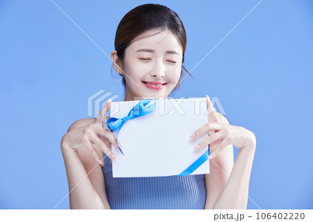 beauty concept photo of korean asain beautiful woman with closed eyes holing a gift box 106402220