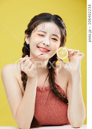 beauty concept photo of korean asain beautiful woman holding a lipgloss and a lemon beauty concept photo of korean asain beautiful woman holding a lipgloss and a lemon 106402238
