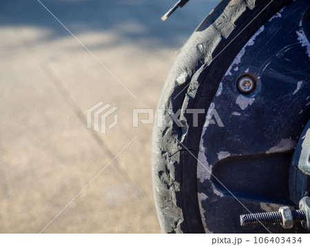 Part of an electric scooter close-up. Broken tire. Broken scooter wheel. Propulsion tool. Part of an electric scooter close-up. Broken tire. Broken scooter wheel. Propulsion tool. 106403434