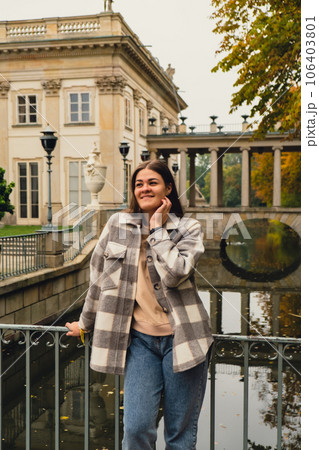 Tourist attraction woman travel enjoying nature sightseeing Baths classicist Palace on the Isle in Lazienki Park touristic place in Warsaw. Lazienki Royal Baths Park, Baroque columns Warsaw Poland 106403801