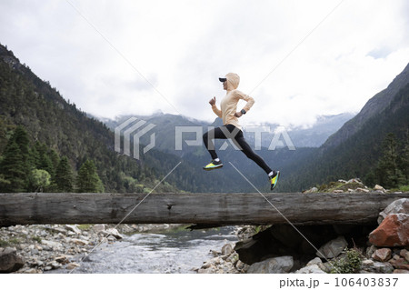 Woman trail runner cross country running in high altitude mountains Woman trail runner cross country running in high altitude mountains 106403837