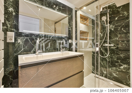 a modern bathroom with black marble walls and flooring, along with a walk - in shower stall on the right side a modern bathroom with black marble walls and flooring, along with a walk - in shower stall on the right side 106405007