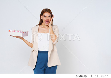 Portrait of a happy smiling young woman holding present box isolated over white background. Portrait of a happy smiling young woman holding present box isolated over white background. 106405027