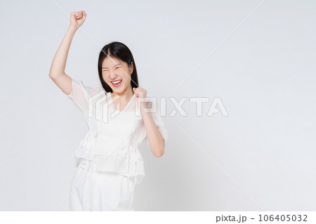 Young asian woman with raised hands celebrating success isolated on white background. Young asian woman with raised hands celebrating success isolated on white background. 106405032