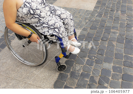 Cropped Adult With Short Stature On Wheelchair Stands On Bus Stop in Street, Outdoor Waiting For Public Transport At Summer Day. Unrecognizable Female Adult With Disability. Transportation. Horizontal 106405977