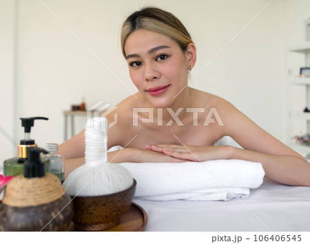 A serene woman reclining leisurely within a soothing spa ambiance, surrounded by elements promoting tranquility. Holistic luxury wellness experience. 106406545