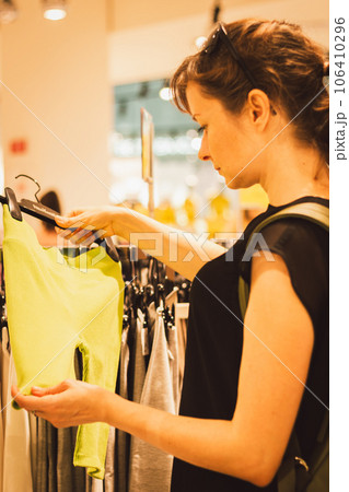 Girl in the shop mall. Shopping concept. Woman looking for casual wear. Trendy clothes. Customer in clothes store. Sales season. Girl buying dress. Woman chooses clothing in boutique. Women leisure.  106410296