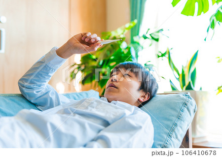 風邪の男性、熱がある男性と体温計 106410678