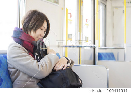 電車で寝るミドル女性 106411311