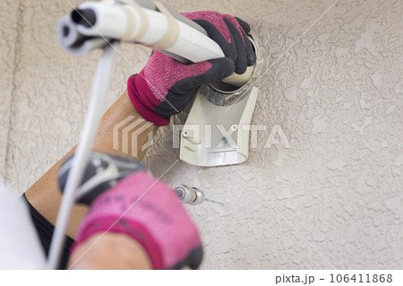 屋外のエアコンの配管を取り付ける男性手元　エアコン取り付け工事 106411868