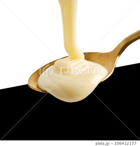 condensed milk pouring into spoon 106412177