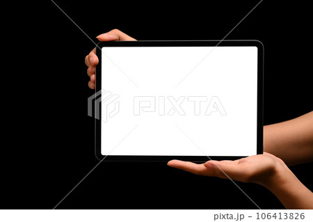 Hands holding digital tablet on black background. Blank screen for your advertising text or promotional content 106413826
