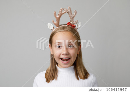 Christmas surprised child girl in Xmas hair deco on white background 106415947