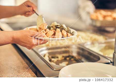 Close-up of a woman hands putting food on her plate, self-service in the dining room. High quality photo Close-up of a woman hands putting food on her plate, self-service in the dining room. High quality photo 106417332