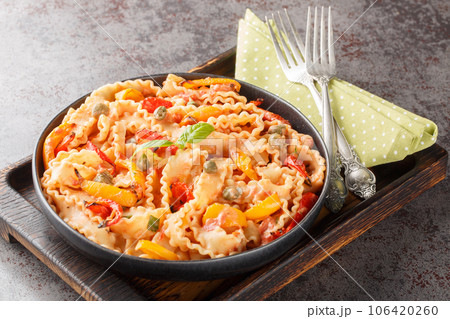 Reginette Pasta With Bell Peppers and Basil in Creamy Tomato Sauce with capers closeup on the plate. Horizontal Reginette Pasta With Bell Peppers and Basil in Creamy Tomato Sauce with capers closeup on the plate. Horizontal 106420260