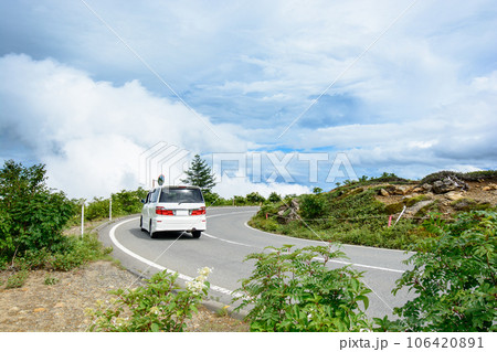 標高の高い山道を走るファミリーカー 106420891