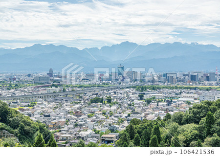 富山県富山市　立山連峰を背後に見る夏の富山駅周辺の街並み 106421536