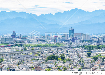 富山県富山市　立山連峰を背後に見る夏の富山駅周辺の街並み 106421537