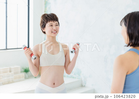 ダンベルでトレーニングする若い女性 106423820