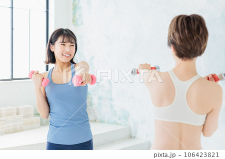 ダンベルでトレーニングする若い女性 106423821