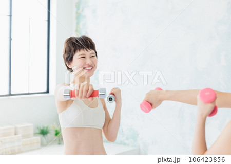 ダンベルでトレーニングする若い女性 106423856