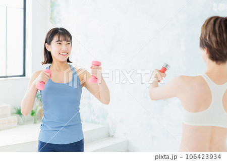 ダンベルでトレーニングする若い女性 106423934