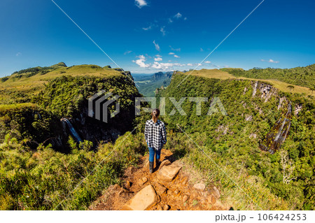 Hiker woman staying on cliff in Espraiado Canyon park in Santa Catarina, Brazil. Panoramic view 106424253