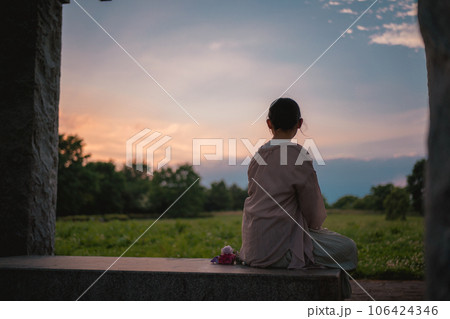 夕日を眺める女性 106424346