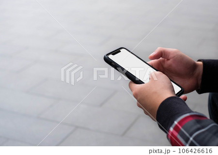 Holding mobile phone with copy space background 106426616