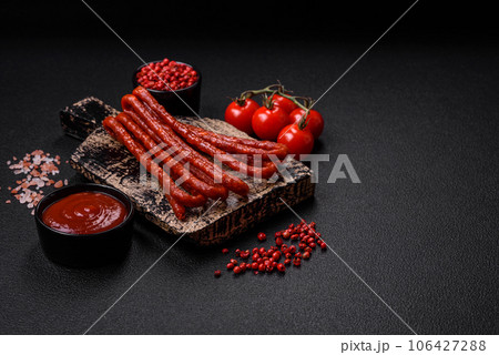 Delicious thin smoked hunting sausages with salt, spices and herbs 106427288