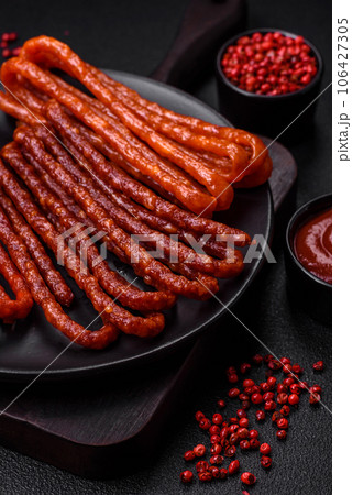 Delicious thin smoked hunting sausages with salt, spices and herbs 106427305