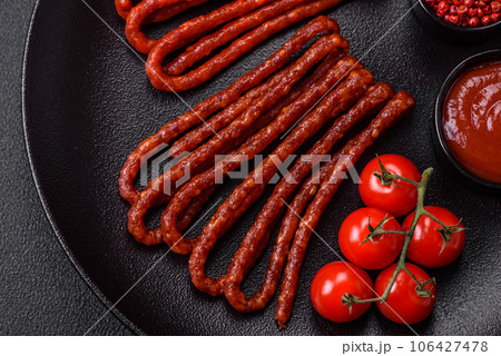 Delicious thin smoked hunting sausages with salt, spices and herbs 106427478