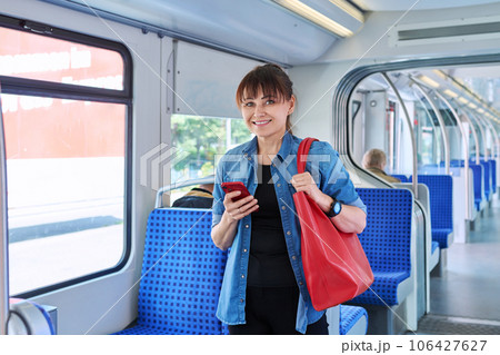 Woman is a passenger inside an electric train car 106427627
