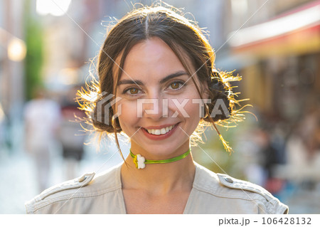 Happy young woman smiling looking away dreaming, resting, good news, feel satisfied in city street Happy young woman smiling looking away dreaming, resting, good news, feel satisfied in city street 106428132