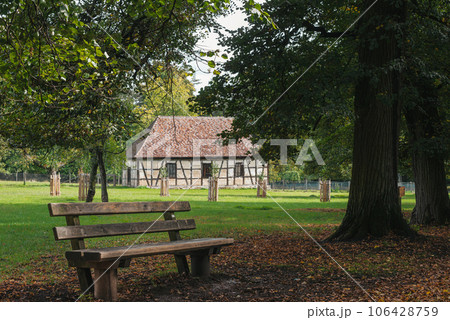 Calm Fall Season in German Park. Beautiful Landscape With Road In Autumn Forest. Bench in the Autumn Park. Maples And Birch Trees With Green, Yellow And Orange Leaves And Footpath In The Woodland In Calm Fall Season in German Park. Beautiful Landscape With Road In Autumn Forest. Bench in the Autumn Park. Maples And Birch Trees With Green, Yellow And Orange Leaves And Footpath In The Woodland In 106428759
