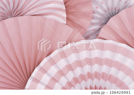 Pink and white background. Top view of two colors paper fans piled up in layers. 106428991
